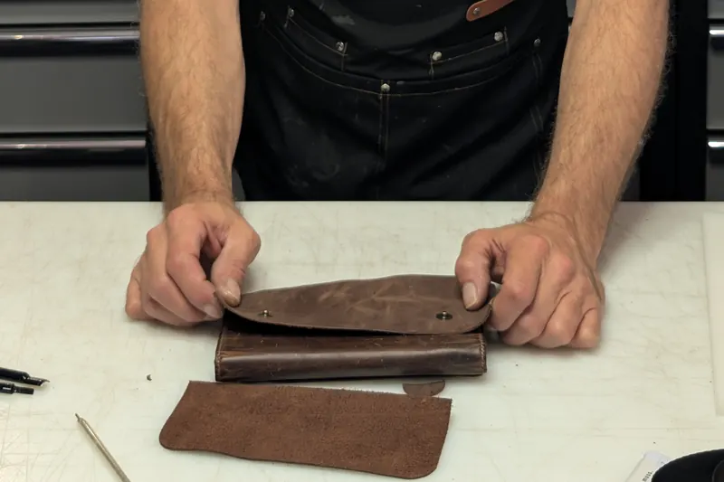 The master's hands working the leather